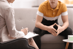 a counselor talks to a teen and addresses common adolescent treatment FAQs