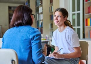a teen boy talks to a therapist during adderall addiction treatment